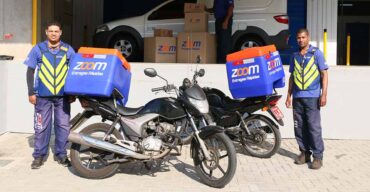 Dois funcionários da Zoom oferecendo serviços de motoboy para empresas